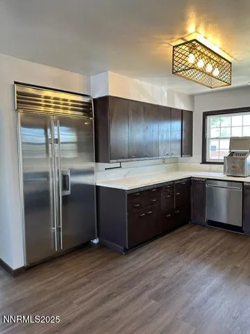 a kitchen with stainless steel appliances kitchen island granite countertop a refrigerator and a sink