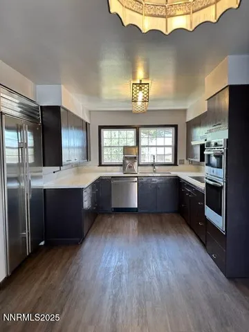 a large kitchen with a large counter top stainless steel appliances and a window