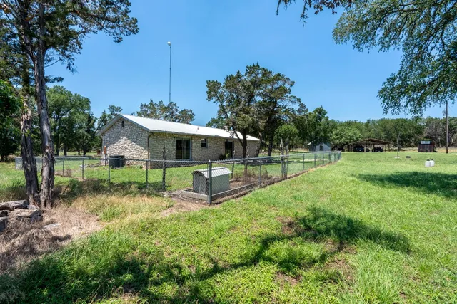 a view of a house with backyard and sitting area