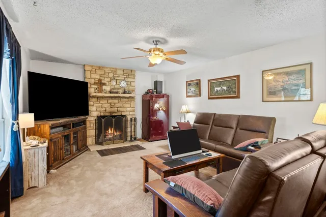 a living room with furniture a flat screen tv and a fireplace