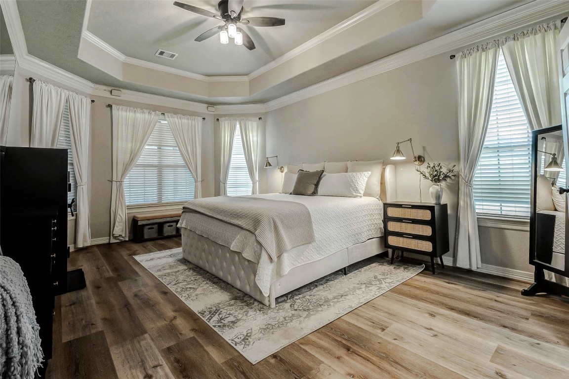 4403 Wickby Street Fulshear, TX 77441 - Photo 21 of 50 Fall in love with the oversized primary retreat featuring exquisite tray ceilings, crown molding, and a ceiling fan to create a serene and tranquil atmosphere.