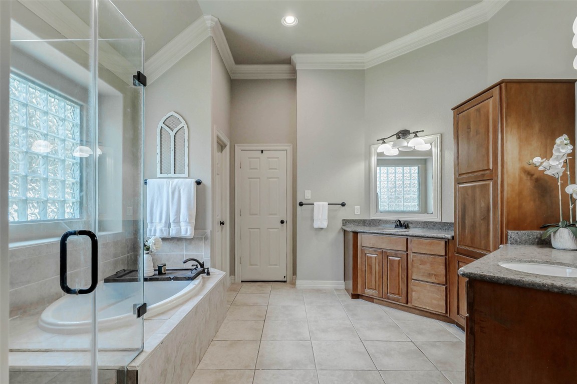 4403 Wickby Street Fulshear, TX 77441 - Photo 23 of 50 Inside the ensuite bathroom, you will enjoy dual sink vanities that provide dedicated spaces for your daily routines. Each vanity topped with granite and is equipped with large mirrors, overhead vanity lighting, and spacious cabinets with drawers, offering both functionality and style.