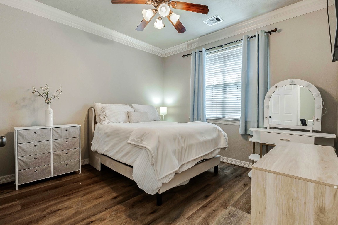 4403 Wickby Street Fulshear, TX 77441 - Photo 28 of 50 This comfortable secondary bedroom provides a light neutral palette with crown molding and a ceiling fan.
