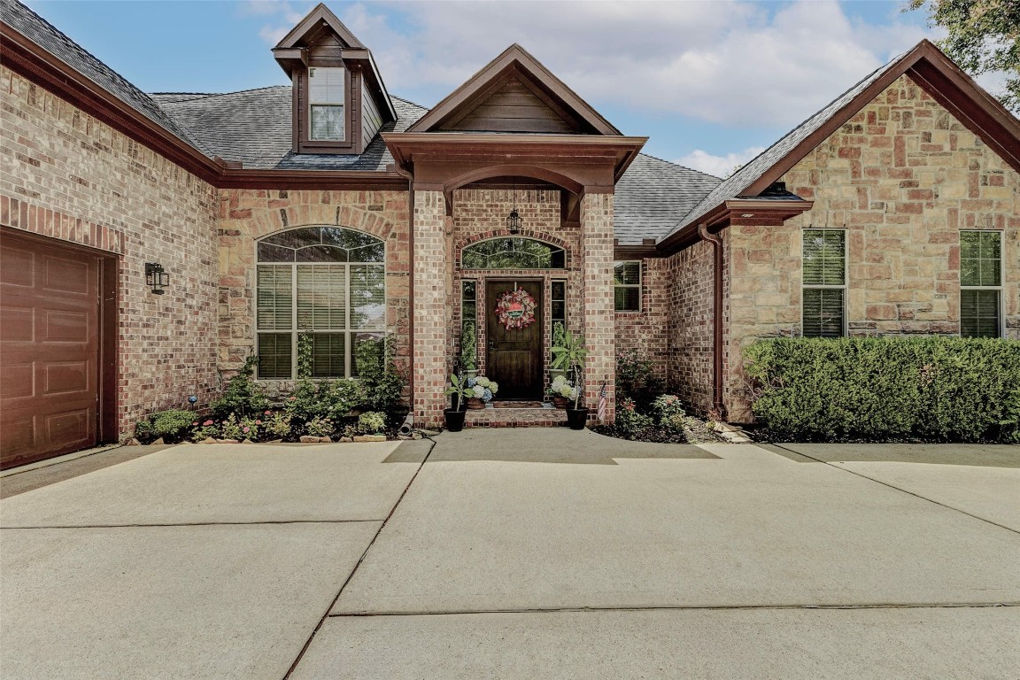 4403 Wickby Street Fulshear, TX 77441 - Photo 3 of 50 The gable roof and classic brick and stone facade make for a welcoming entryway framed by columns.