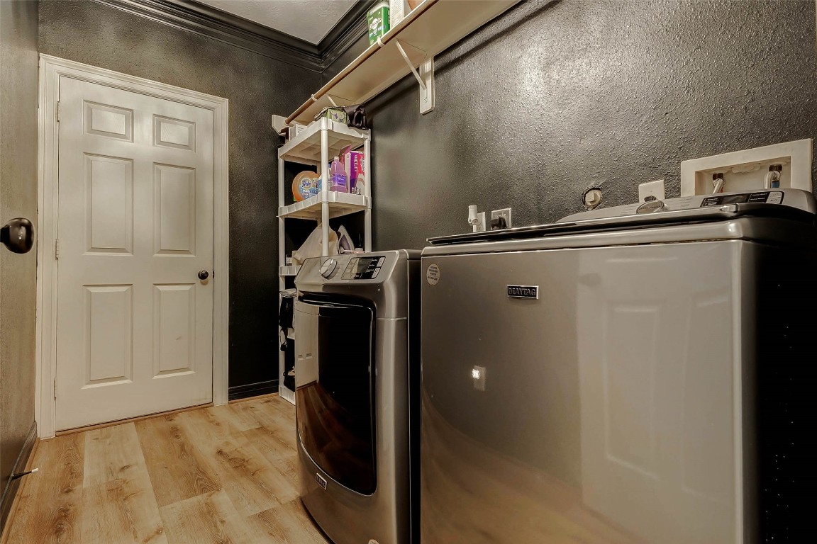 4403 Wickby Street Fulshear, TX 77441 - Photo 38 of 50 Leading to the garage, the roomy laundry room provides plenty of space for full-sized appliances, with both gas and electric connections available for your dryer. The shelving above ensures that your laundry essentials stay neatly organized.