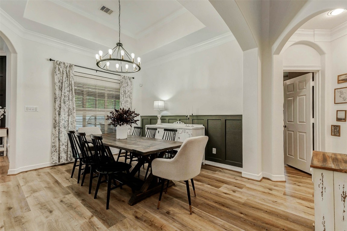 4403 Wickby Street Fulshear, TX 77441 - Photo 8 of 50 The elegant formal dining room is designed for memorable gatherings & entertaining. It offers large windows allowing natural light to fill the room. The tray ceiling, enhanced with crown molding, adds an extra touch of intricacy, while a beautiful chandelier serves as a striking centerpiece.