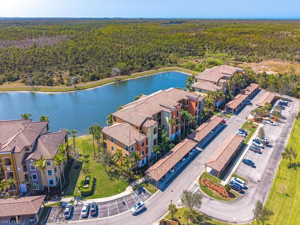 9731 Acqua Court, Unit 514 Naples, FL 34113 - Photo 19 of 21 Aerial view of a forest and a large body of water