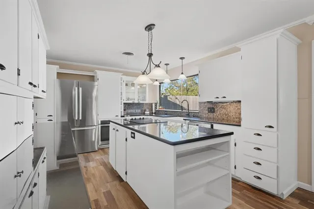 a kitchen with stainless steel appliances a stove and refrigerator