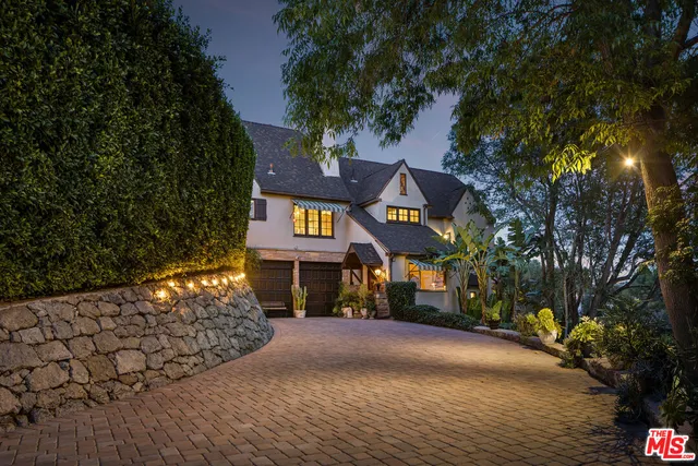 a front view of a house with a yard and tree s