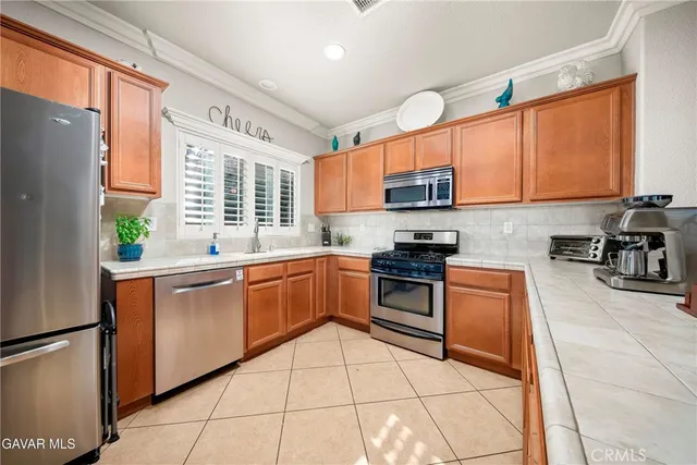 a large kitchen with stainless steel appliances granite countertop a stove a sink a microwave and a refrigerator