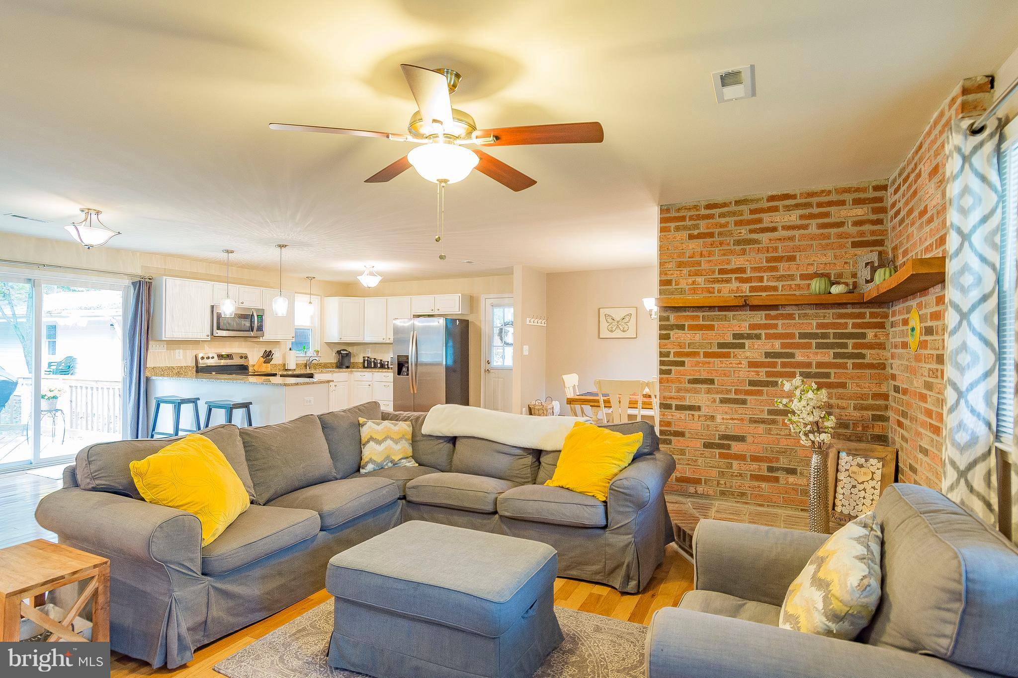 1218 Calvert Beach Road St. Leonard, MD 20685 - Photo 15 of 29 a living room with patio furniture and a chandelier