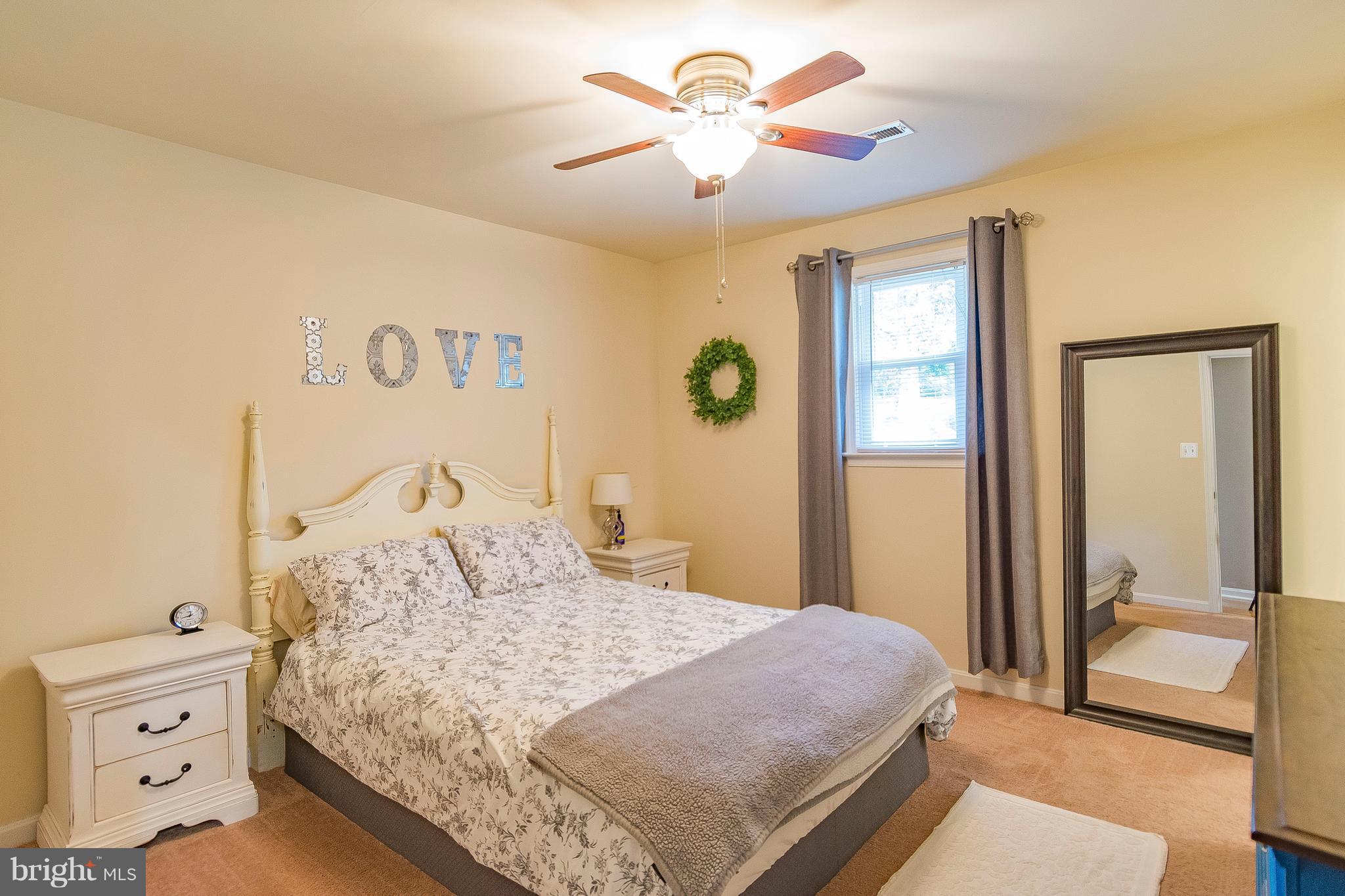 1218 Calvert Beach Road St. Leonard, MD 20685 - Photo 19 of 29 a bedroom with a large bed and a chandelier