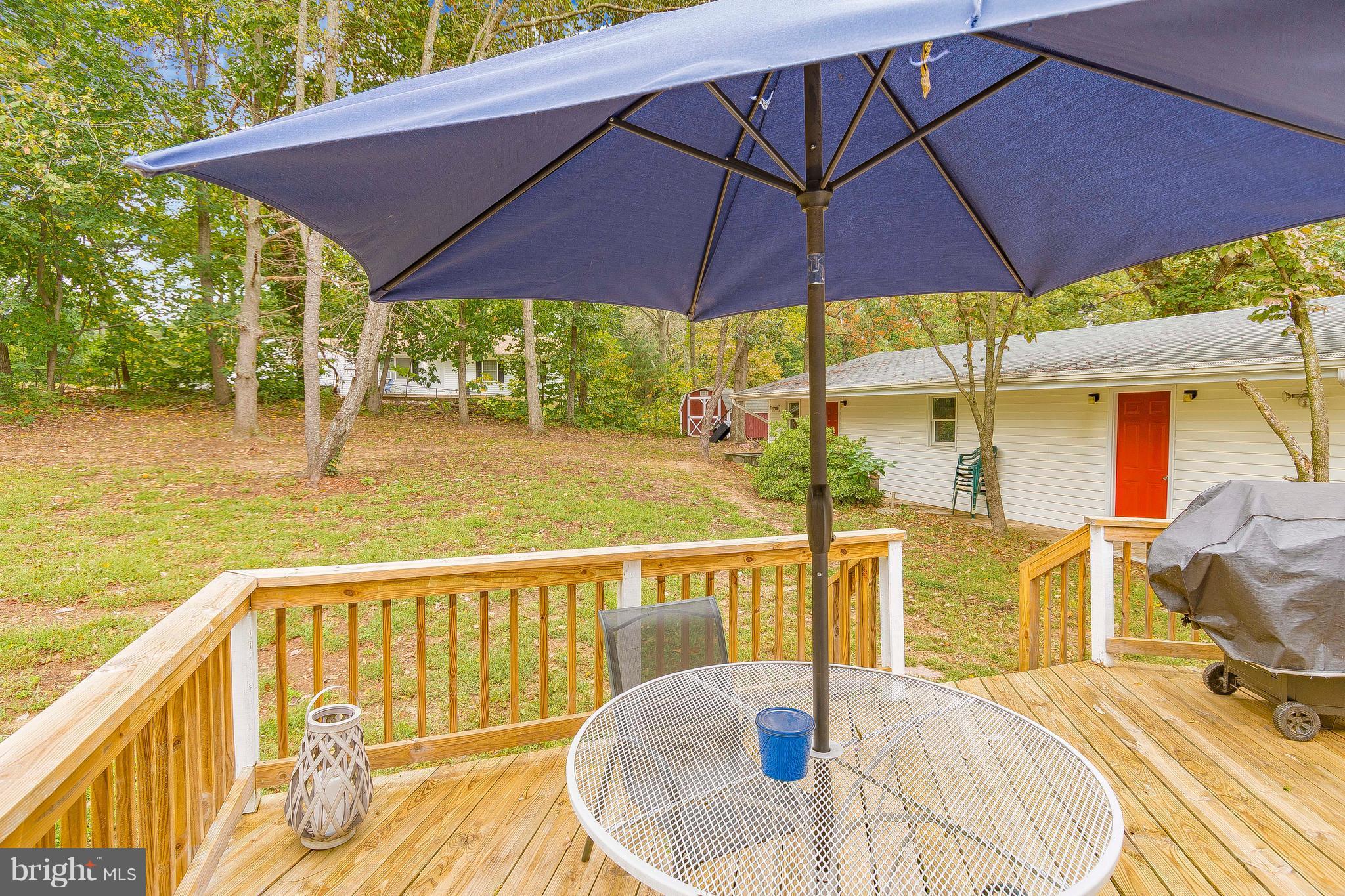 1218 Calvert Beach Road St. Leonard, MD 20685 - Photo 23 of 29 a view of a balcony with chair and umbrella