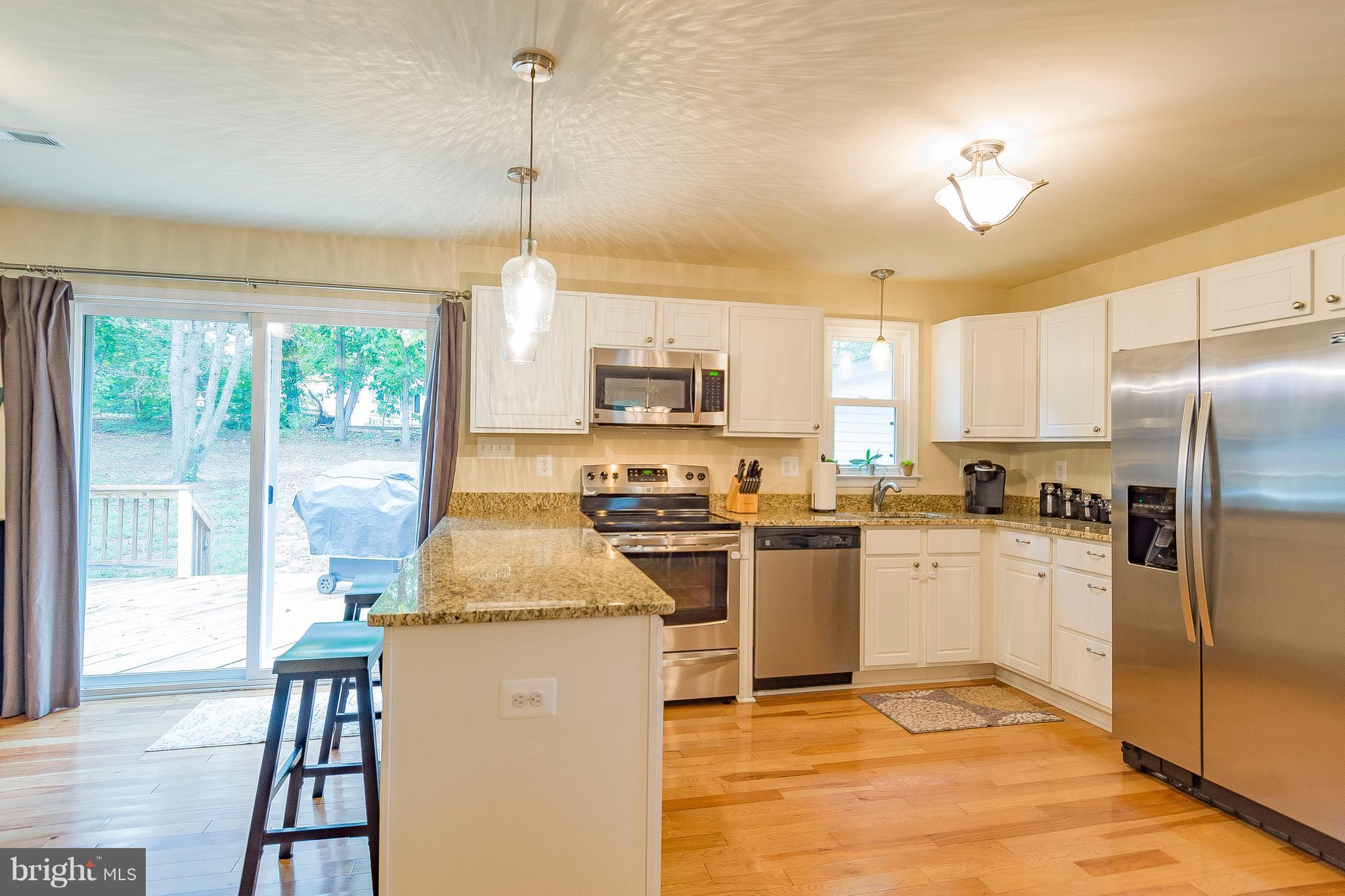 1218 Calvert Beach Road St. Leonard, MD 20685 - Photo 8 of 29 a kitchen with a stove a sink and a refrigerator