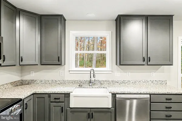 a kitchen with granite countertop stainless steel appliances a stove a microwave and cabinets