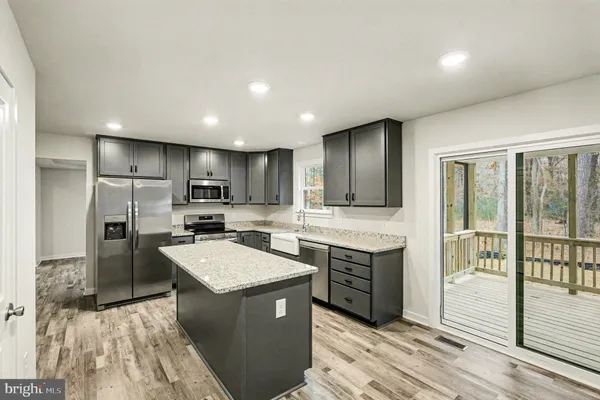 a kitchen with stainless steel appliances a sink a stove a refrigerator and cabinets