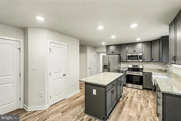 a kitchen with a refrigerator a sink and wooden cabinets