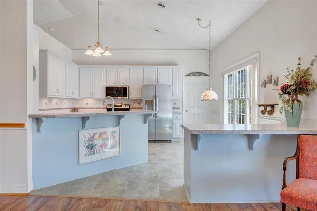 a kitchen with stainless steel appliances granite countertop a refrigerator and a stove top oven