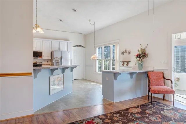a view of a kitchen with white cabinets and a window