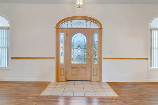 a dining room with chandelier and wooden floor
