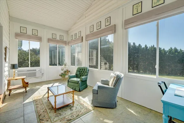 an empty room with wooden floor chandelier and windows