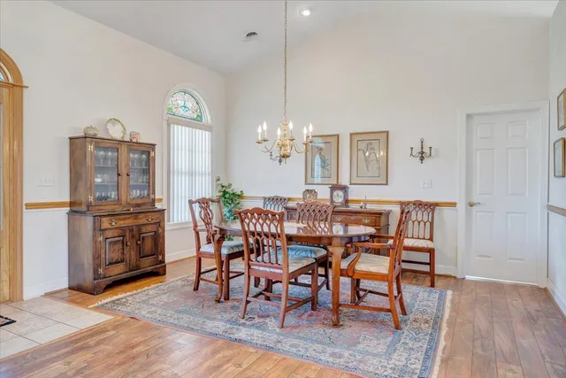a dining room with furniture a chandelier and wooden floor