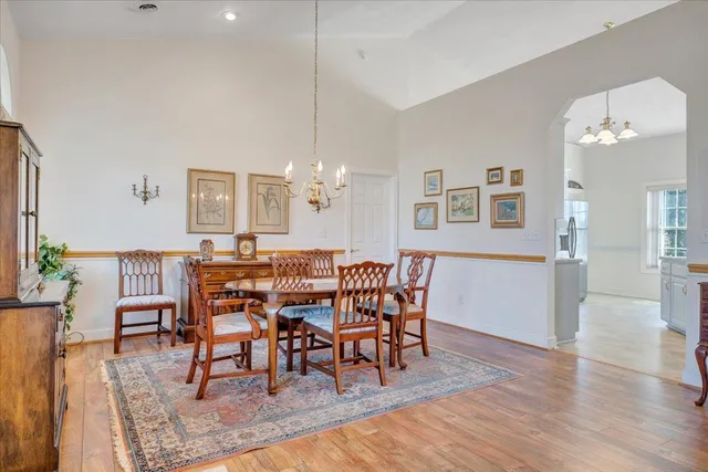 a dining room with furniture a chandelier and wooden floor