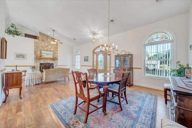 a view of a dining room with furniture a chandelier and wooden floor
