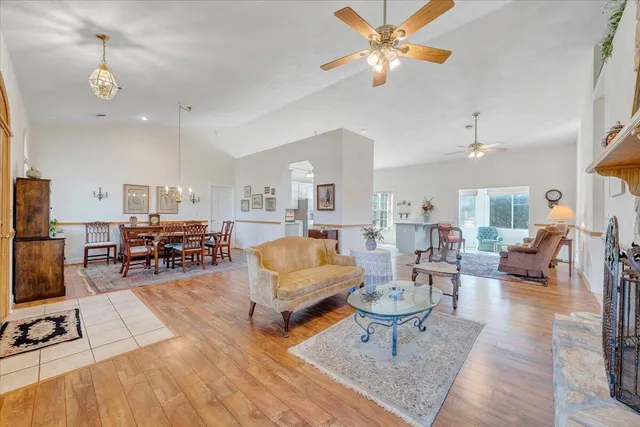 a living room with furniture a rug and kitchen view