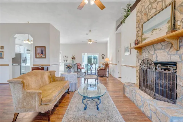 a living room with furniture a fireplace and a chandelier