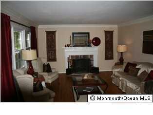 60 Newbury Road Howell, NJ 07731 - Photo 3 of 3 a living room with furniture a flat screen tv and a fireplace