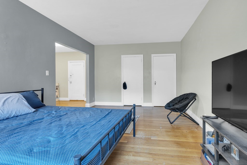65 Strathmore Road, Unit 21 Boston, MA 02135 - Photo 3 of 10 a bedroom with a bed and wooden floor