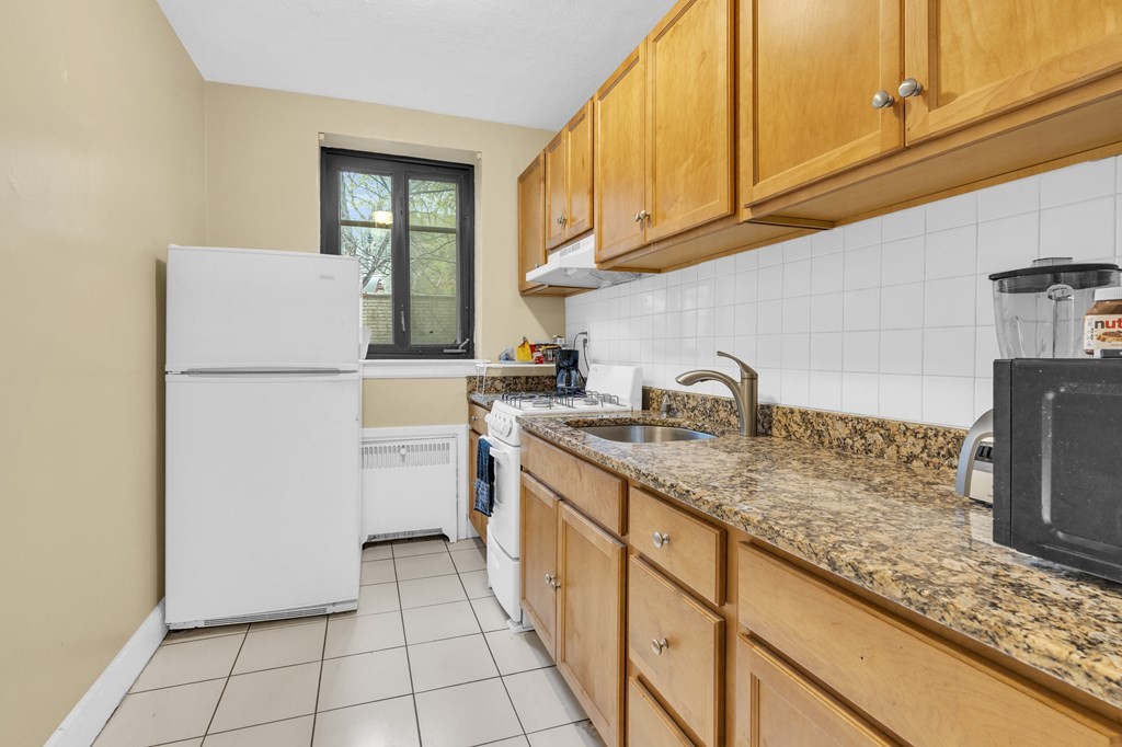 65 Strathmore Road, Unit 21 Boston, MA 02135 - Photo 7 of 10 a kitchen with a sink a refrigerator and cabinets