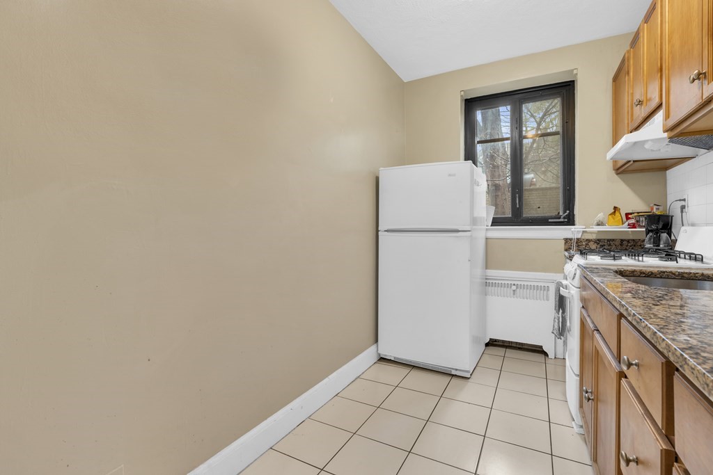 65 Strathmore Road, Unit 21 Boston, MA 02135 - Photo 8 of 10 a kitchen with a refrigerator a stove a washer and dryer