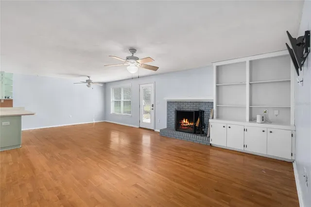 a view of an empty room with a fireplace and a window
