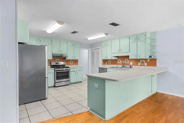 a kitchen with stainless steel appliances a refrigerator and a stove top oven