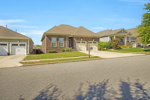 a front view of a house with a yard and potted plants