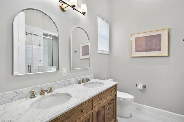 a bathroom with a granite countertop toilet a sink and mirror