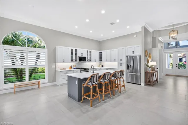 a kitchen with stainless steel appliances kitchen island granite countertop a refrigerator and a sink