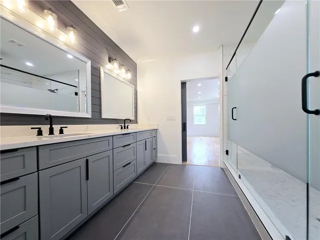 a bathroom with 2 sink mirror and window