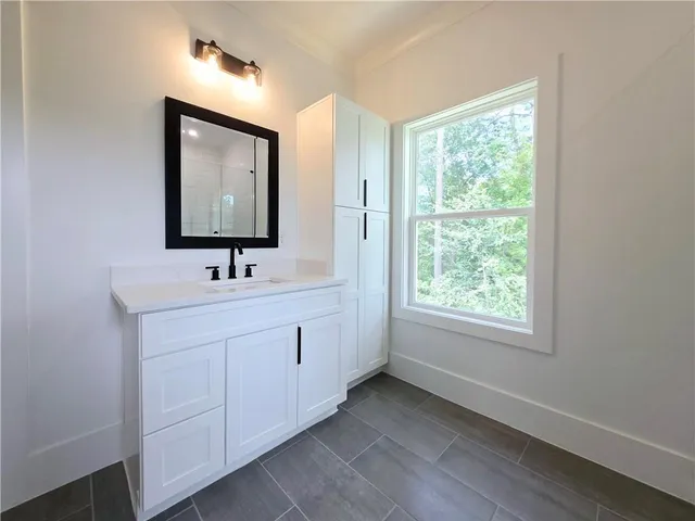 a spacious bedroom with a bed and a flat screen tv