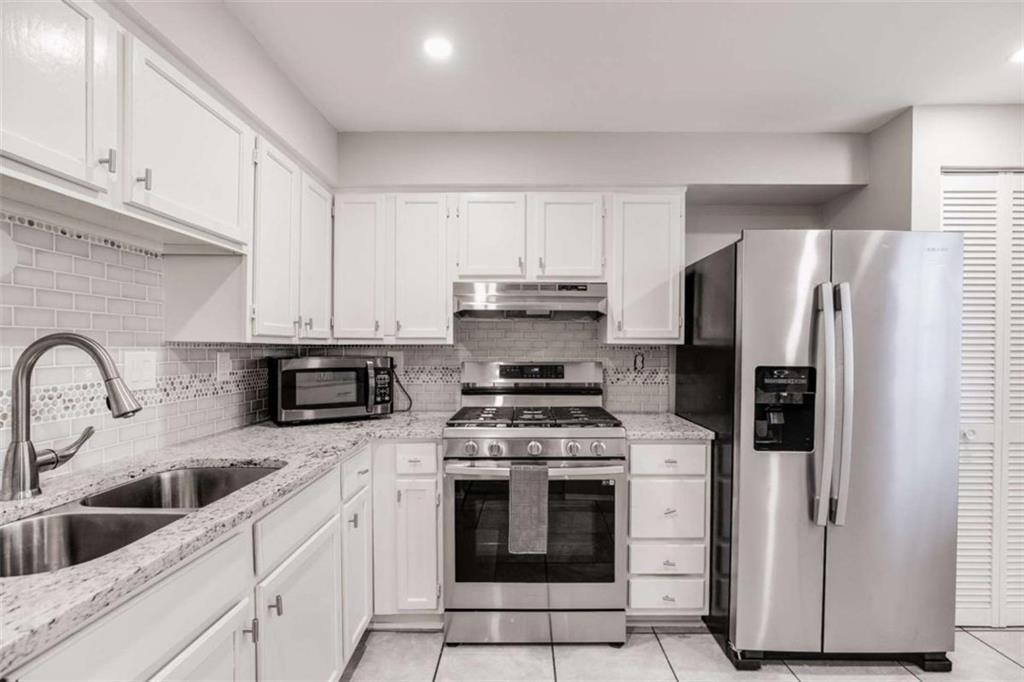 6413 Wedgewood Trace Tucker, GA 30084 - Photo 11 of 30 a kitchen with stainless steel appliances granite countertop white cabinets a refrigerator a stove a sink and white cabinets