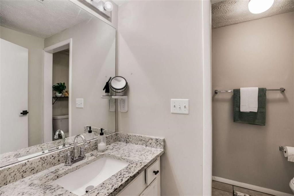 6413 Wedgewood Trace Tucker, GA 30084 - Photo 17 of 30 a bathroom with a granite countertop sink and a mirror