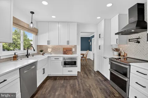 a kitchen with granite countertop white cabinets and white appliances