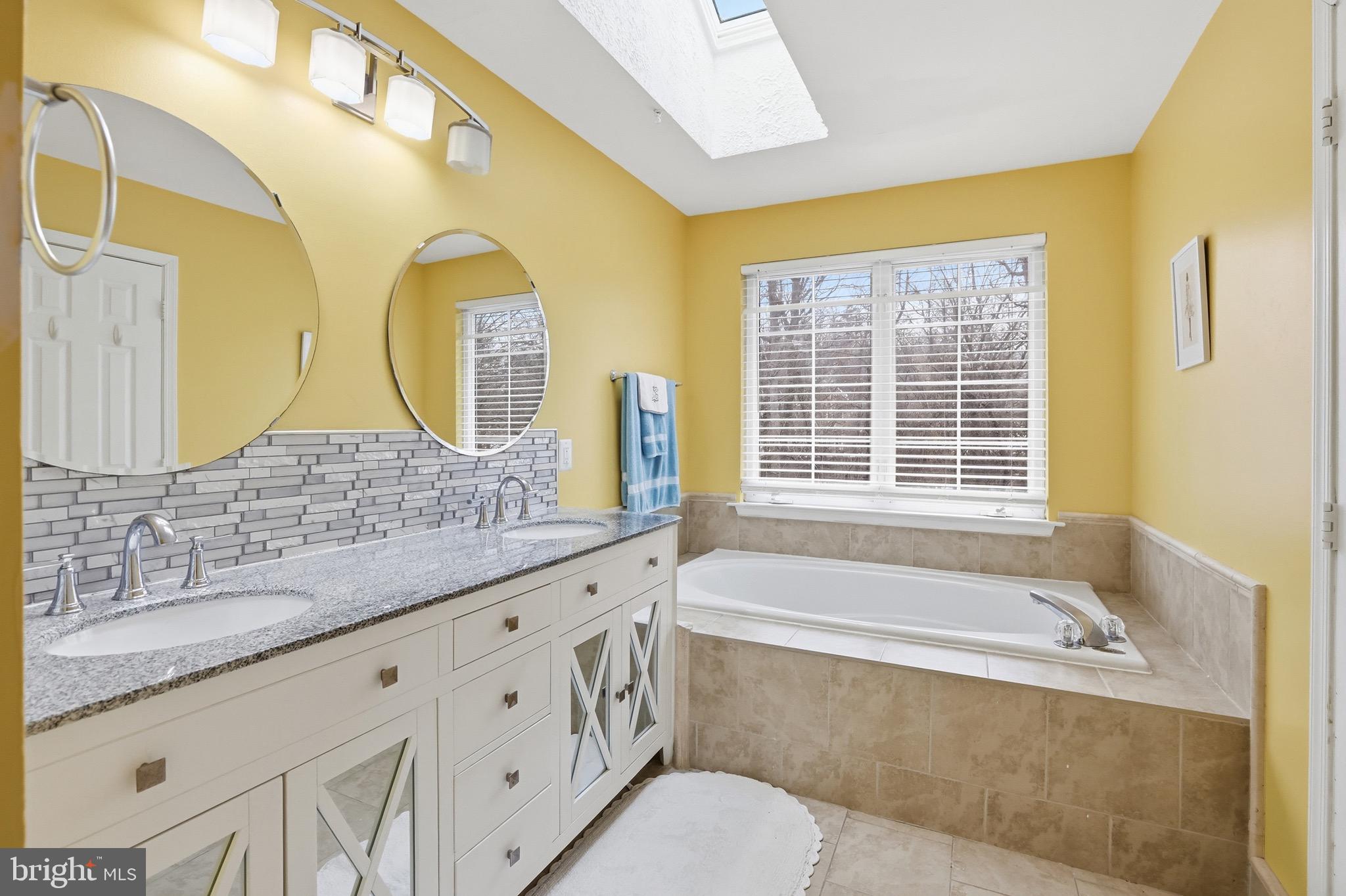 3045 Button Bush Lane Laurel, MD 20724 - Photo 21 of 28 a bathroom with a granite countertop tub a sink and a large mirror