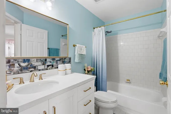 a bathroom with a sink a toilet and a large mirror