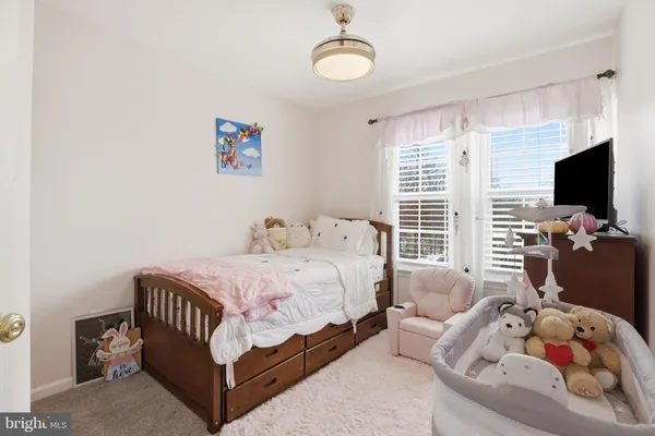 a spacious bedroom with a bed and a flat screen tv