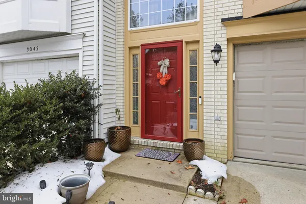 a view of a door of the house with potted plants