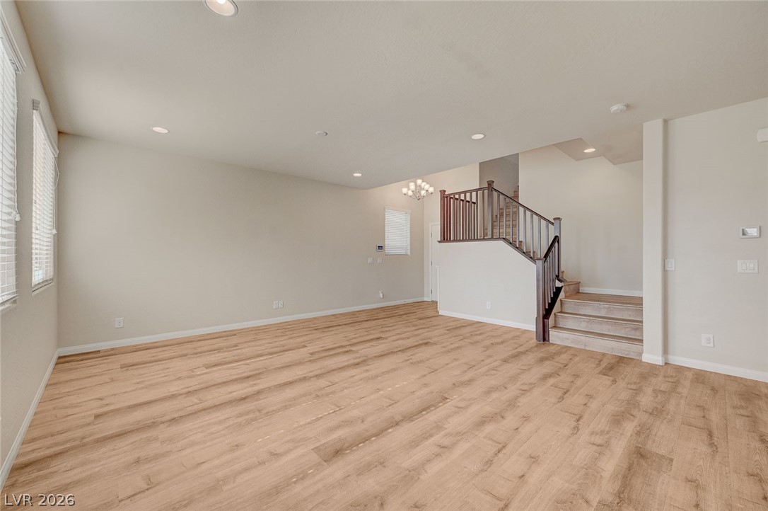 113 Elm Reed Avenue Las Vegas, NV 89113 - Photo 11 of 62 Unfurnished living room with light wood-type flooring and hanging lights