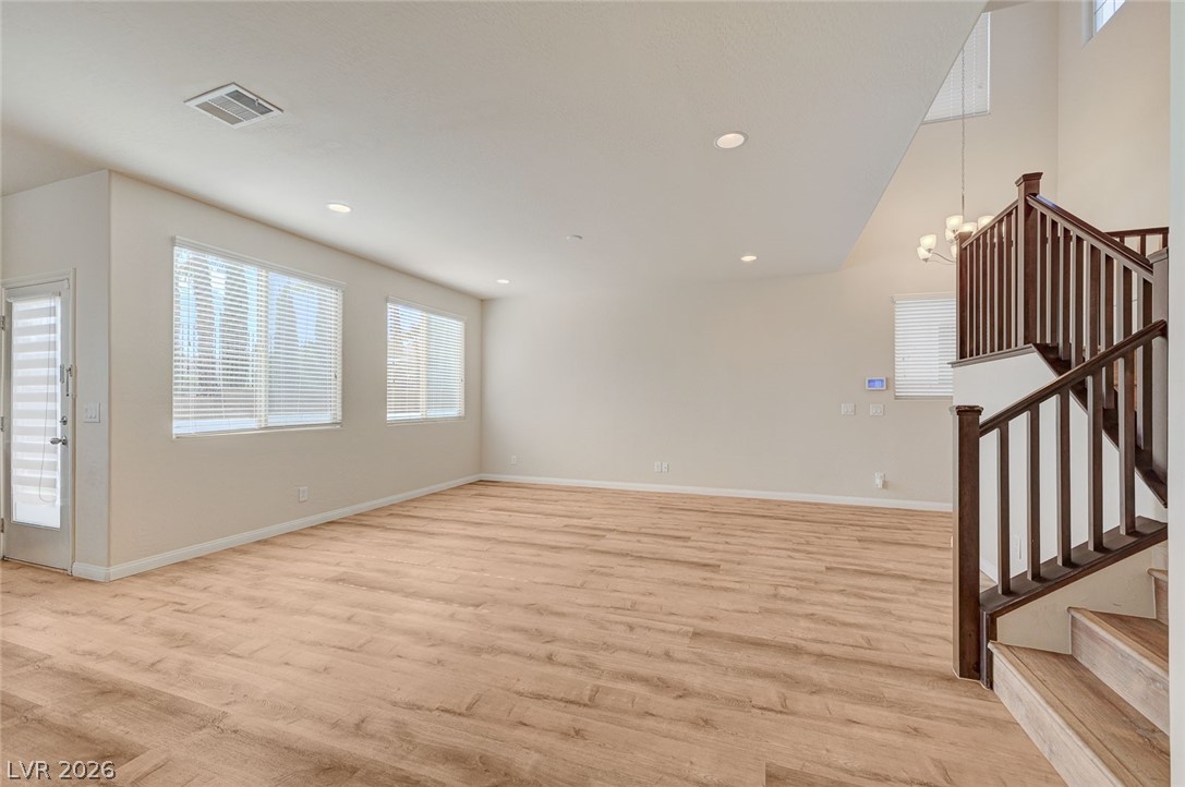 113 Elm Reed Avenue Las Vegas, NV 89113 - Photo 12 of 62 Unfurnished living room with healthy amount of natural light, light wood finished floors, suspended lighting, and a high ceiling
